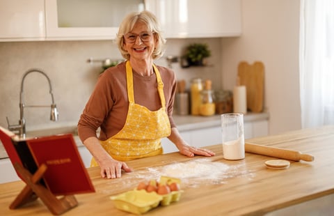 Author holding her finished cookbook in her kitchen
