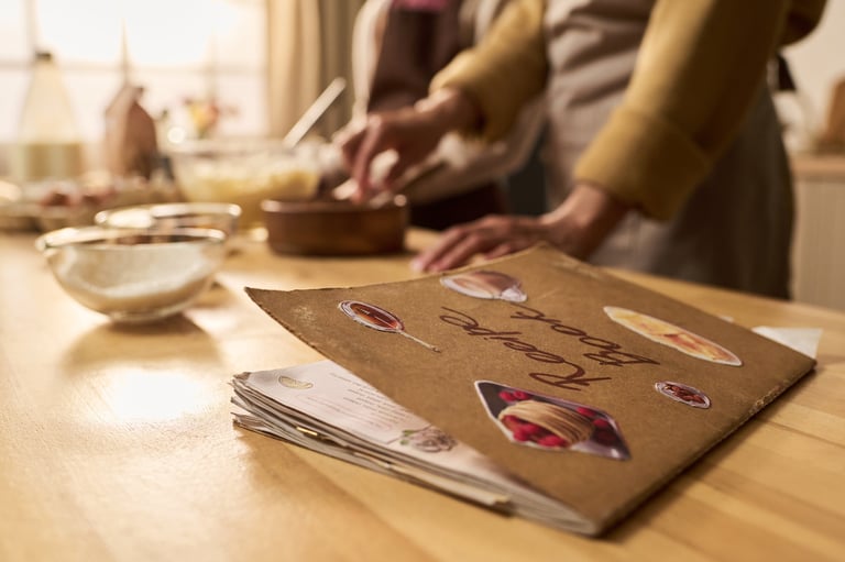 Turning recipes into a professionally designed cookbook, with recipe pages and fresh ingredients on a kitchen table