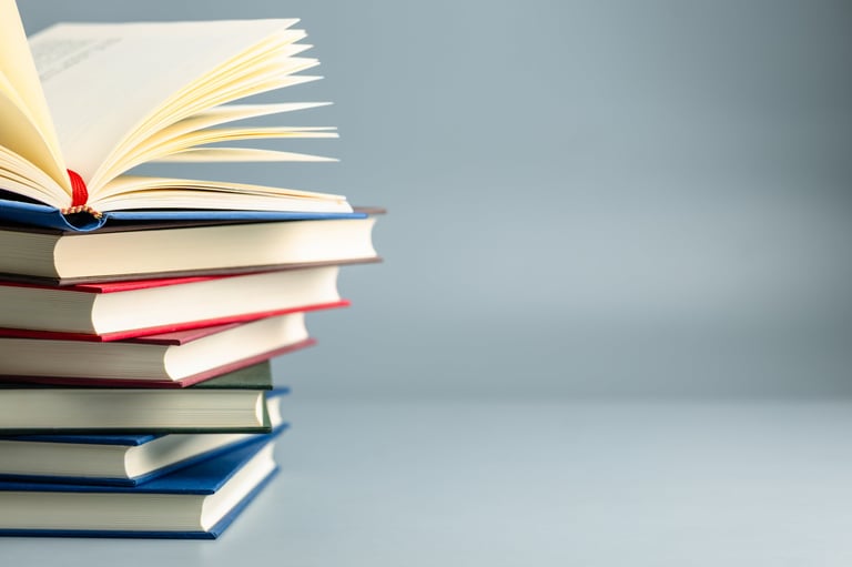 Professionally published hardcover cookbook resting on a stack of books